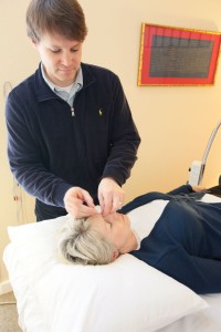 Patient receiving acupuncture between her eyebrows at yin tang point.